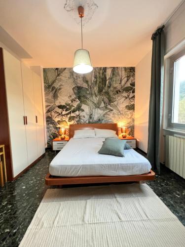 um quarto com uma cama com um quadro na parede em Green House Nonna Angela em Spotorno