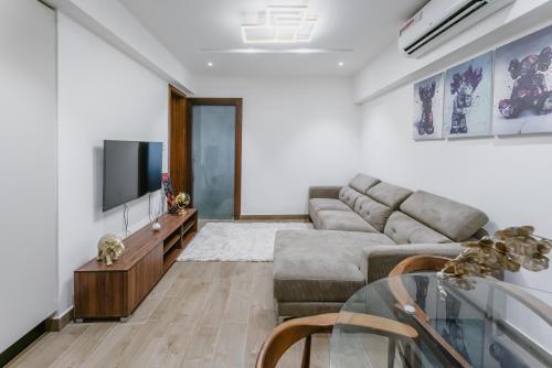a living room with a couch and a tv at Rosewood luxury 1 bedroom @ Solaris in Accra