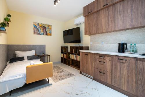 a bedroom with a bed and a kitchen with a tv at Chopina Cosy Apartment in Katowice