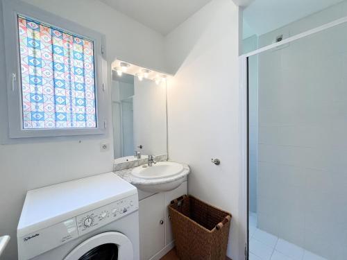 une salle de bain avec un lavabo et une machine à laver dans l'établissement Appartement une chambre dans residence calme, à Propriano