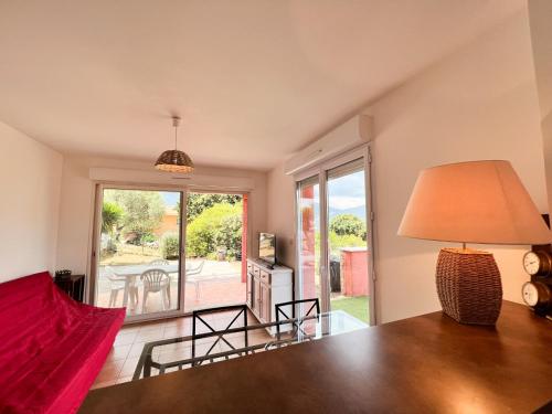 un salon avec une table et une lampe dans l'établissement Appartement une chambre dans residence calme, à Propriano