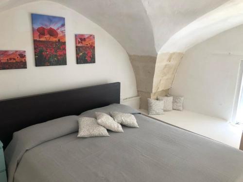 1 dormitorio con 1 cama con 3 almohadas en NONNA SALENTO, en San Cesario di Lecce