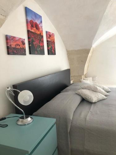 - une chambre dotée d'un lit avec 3 photos sur le mur dans l'établissement NONNA SALENTO, à San Cesario di Lecce