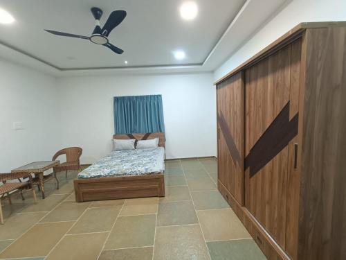 1 dormitorio con 1 cama y armario de madera en Rama Farms, en Sangamner