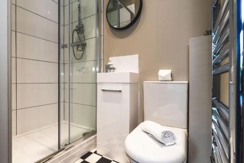 uma casa de banho com um WC e uma cabina de duche em vidro. em Stunning Apartment Derby Free Wi-Fi & Parking em Derby