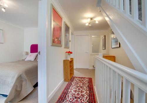 a bedroom with a bed and a staircase with a stair case at 7 Sea Mews in Cromer
