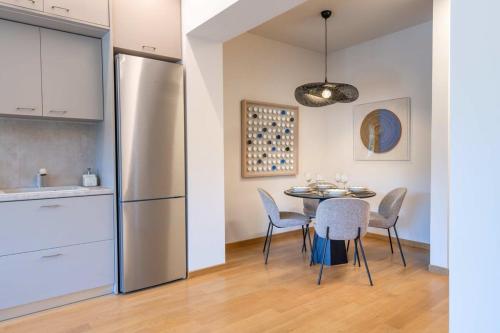 a kitchen and dining room with a table and a refrigerator at Touching Acropolis - Quiet & Elegant 1-Bdr Apt in Athens