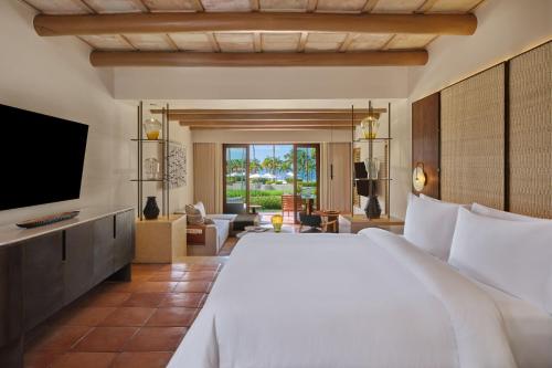 1 dormitorio con 1 cama grande y TV en The St. Regis Punta Mita Resort, en Punta Mita