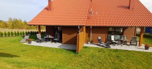 a house with an orange roof with a table and chairs at Premiumferienhaus Bhakti in Hasselfelde