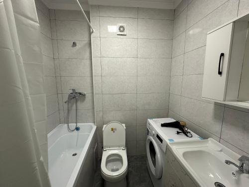 La petite salle de bains est pourvue de toilettes et d'un lavabo. dans l'établissement ЖК Ashyq Tobe, à Almaty