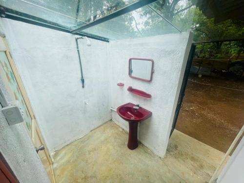 een badkamer met een rood toilet in een gebouw bij Ima Villa Sigiriya in Sigiriya