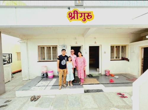 a family standing in front of a building at Shriguru Guest House Akkalkot in Akalkot