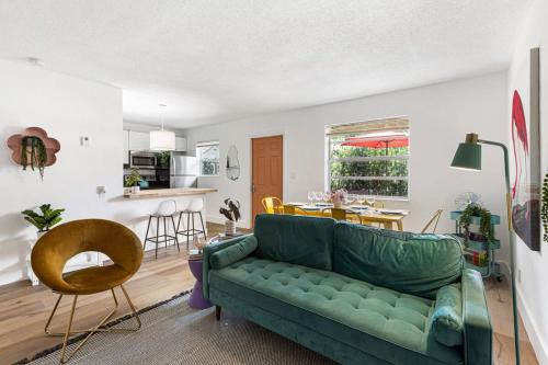 a living room with a green couch and a kitchen at Stylish 2 BR Condo - Free Parking on Premises in Fort Lauderdale