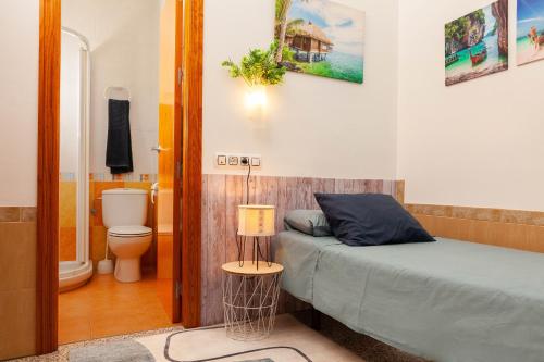 1 dormitorio con 1 cama y baño con aseo en ALOJAMIENTO Aire De Los Alcores, en El Viso del Alcor