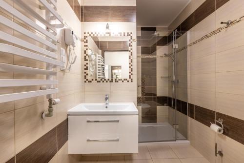 a bathroom with a sink and a shower and a mirror at DW Atrium in Polańczyk