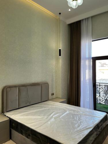 3A, 183, 45m2, Tashkent City Park, Boulevard في طشقند: سرير في غرفة نوم مع نافذة كبيرة
