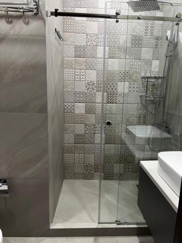 La salle de bains est pourvue d'une douche avec une porte en verre. dans l'établissement 3A, 183, 45m2, Tashkent City Park, Boulevard, à Tachkent