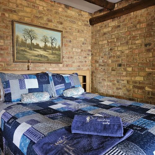 een slaapkamer met een bed in een bakstenen muur bij Villa Dachie in Rayton