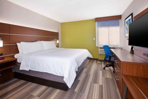 Habitación de hotel con cama, escritorio y TV. en Holiday Inn Express Fairfax-Arlington Boulevard, an IHG Hotel en Fairfax