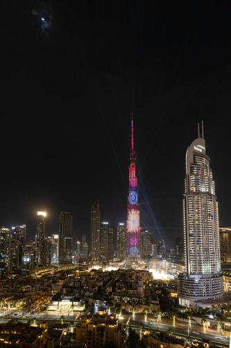 a lit up city at night with a clock tower at SmartStay at Burj Royale - Full Burj Khalifa View - Brand New Luxury Apartments in Dubai