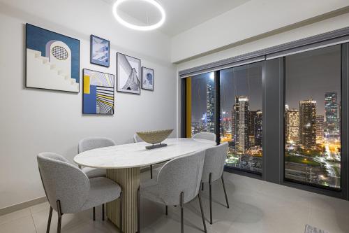 a dining room with a table and chairs and a window at SmartStay at Burj Royale - Full Burj Khalifa View - Brand New Luxury Apartments in Dubai