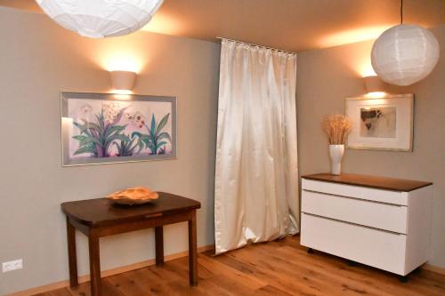 a room with a dresser and a table and a window at Domizil Eutschützblick in Bannewitz