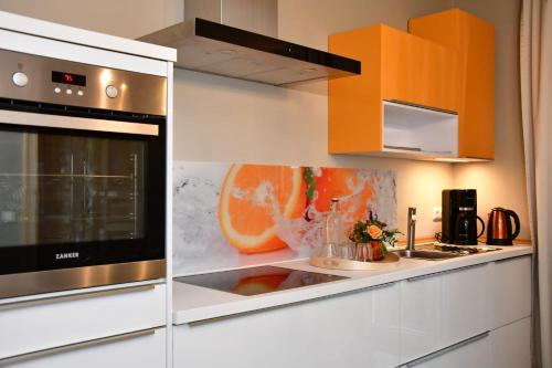 a kitchen with an orange painting on the wall at Domizil Eutschützblick in Bannewitz