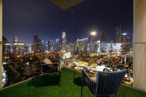 a view of a city at night from a balcony at SmartStay at Burj Royale - Full Burj Khalifa View - Brand New Luxury Apartments in Dubai