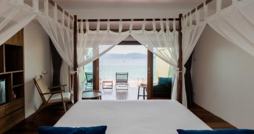 a bedroom with a bed and a view of the ocean at The Cliff Lipe in Ko Lipe