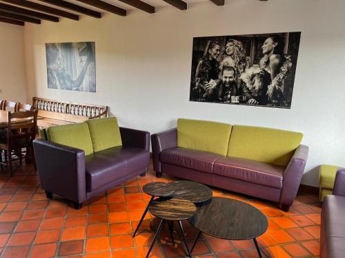 a living room with two couches and a table at Résidence Thier Antoine in Noiseux