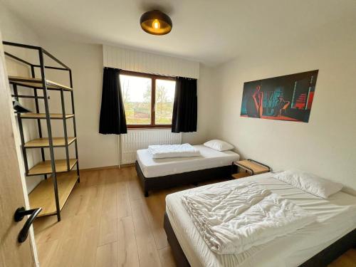 1 dormitorio con 2 camas y estante para libros en Résidence Thier Antoine, en Noiseux