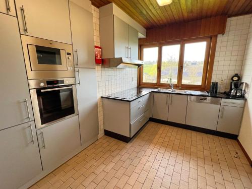 a kitchen with a sink and a stove top oven at Résidence Thier Antoine in Noiseux