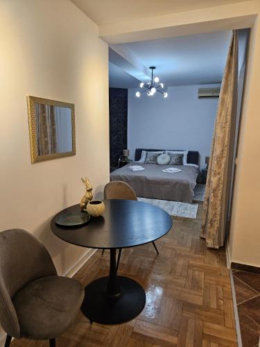 ein Wohnzimmer mit einem Tisch und einem Bett in der Unterkunft Apartman Florida in Kragujevac