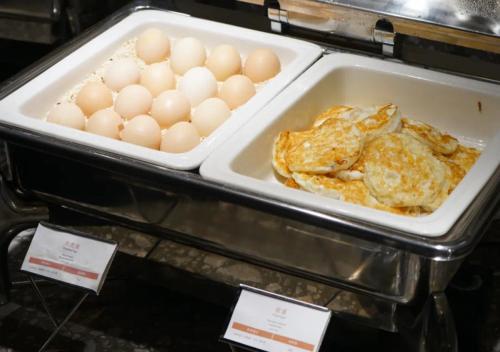 a tray of eggs and pancakes in an oven at Paco Hotel Jinfeng Metro Guangzhou-Free Shuttle Bus For Canton Fair-Self-service laundry in Guangzhou