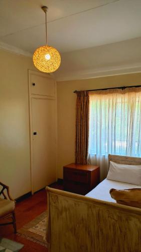 a bedroom with a bed and a window and a chandelier at Zereniti House in Muyaka
