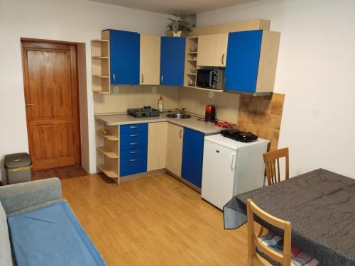 una pequeña cocina con armarios azules y una mesa en Apartmán se dvěma ložnicemi, en Zlín