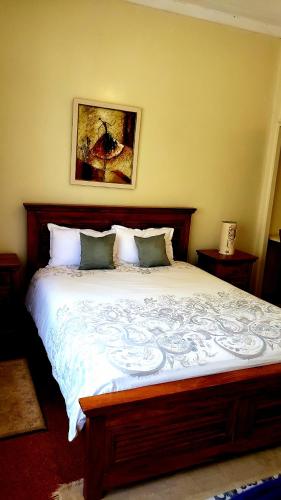 a bedroom with a large bed with white sheets at Zereniti House in Muyaka