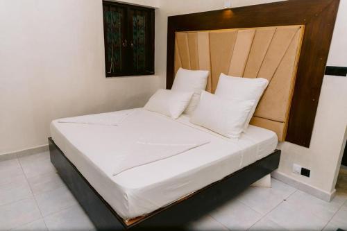 a bed with white sheets and pillows in a room at Romantic garden hotel in Negombo