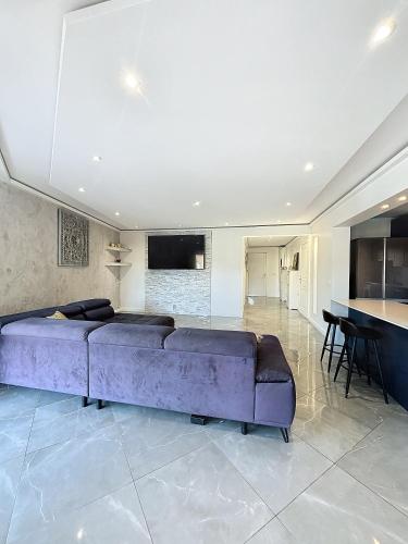 un salon avec un canapé violet et une table dans l'établissement Résidence l'Empire, à Cannes