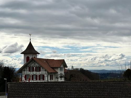 a white house with a tower on top of a roof at Gasthof Sternen Detligen in Detligen