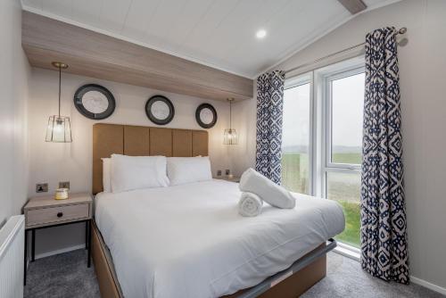 - une chambre avec un grand lit et une fenêtre dans l'établissement Lodge 14 The Riverwood Close to St Andrews, à Strathkinness