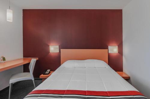 a bedroom with a bed and a desk and a chair at City Express Junior by Marriott Tuxtla Gutierrez Poliforum in Tuxtla Gutiérrez