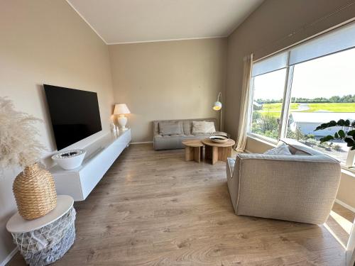 a living room with a television and a couch at Cosy and family friendly 3brd apartment in Akranes in Akranes