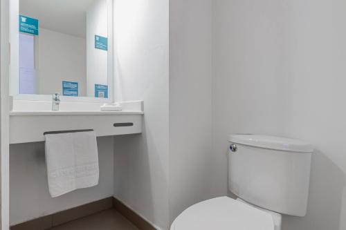 a bathroom with a toilet and a sink and a mirror at City Express Junior by Marriott Tuxtla Gutierrez Poliforum in Tuxtla Gutiérrez