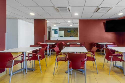 a dining room with tables and red chairs at City Express Junior by Marriott Tuxtla Gutierrez Poliforum in Tuxtla Gutiérrez
