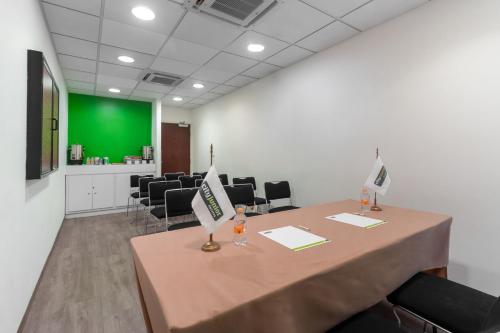 a conference room with a table with chairs and a green screen at City Express Junior by Marriott Tuxtla Gutierrez Poliforum in Tuxtla Gutiérrez