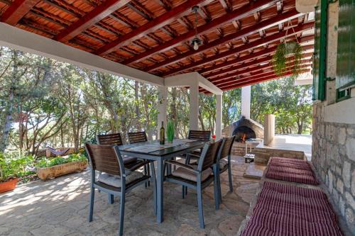 a patio with a table and chairs and a fireplace at Apartman Mario in Korčula