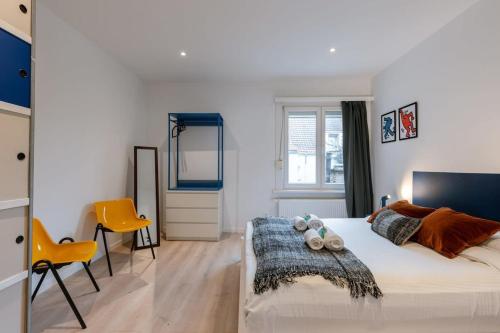 ein Schlafzimmer mit einem großen Bett und zwei gelben Stühlen in der Unterkunft Colorful apartment in the heart of Antwerp in Antwerpen