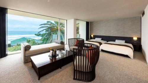 a hotel room with a bed and a view of the ocean at Kamogawa Grand Hotel in Kamogawa