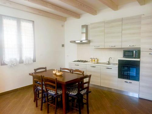 uma cozinha com uma mesa de madeira com cadeiras e um lavatório em Villa La Sosta - 150m dal mare - Patio Privato e Areal Relax em Arenella